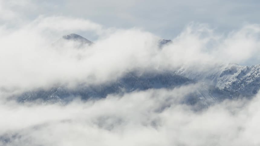 Snow covered mountains through clouds