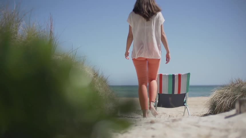 Woman walking towards the water at the beach