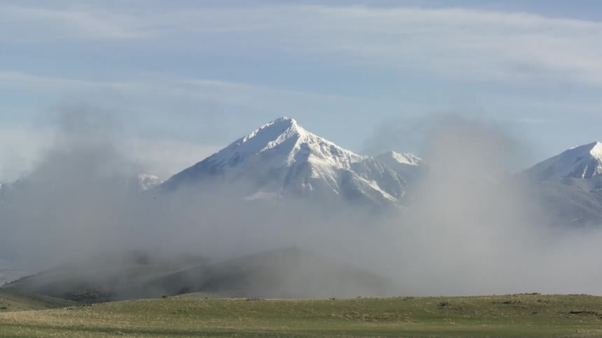 Snow covered mountains through morning fog