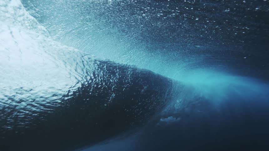 The wave crashes and moves underwater
