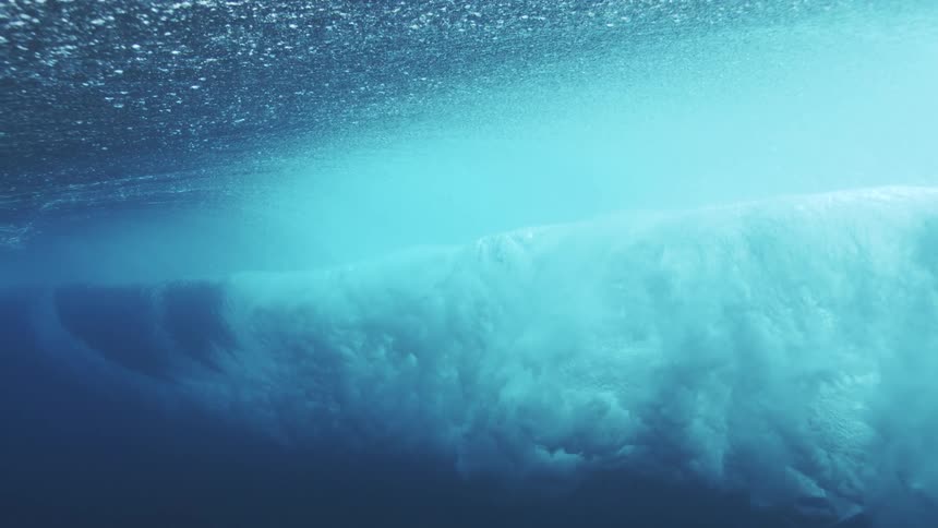 Underwater wave captured in motion under the seas bluish light