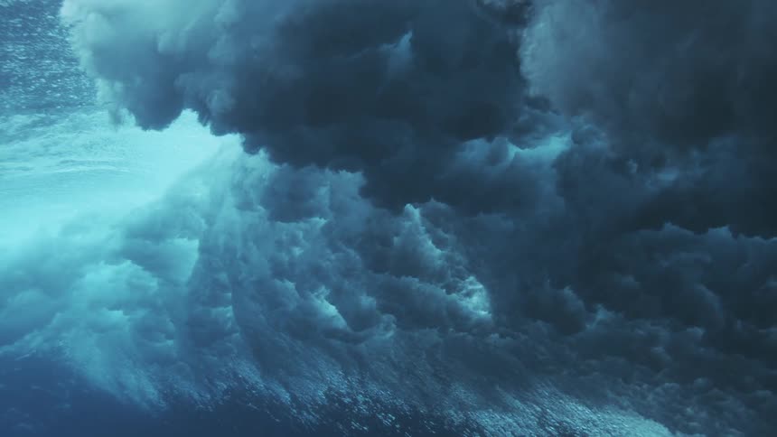 Underwater swell reveals dense bluish texture formed by the foam of the waves