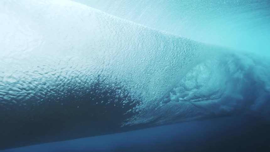 A wave view looking up at a rippled water surface with shifting blue light