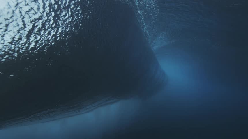 Wave seen from beneath the surface with deep blue tones