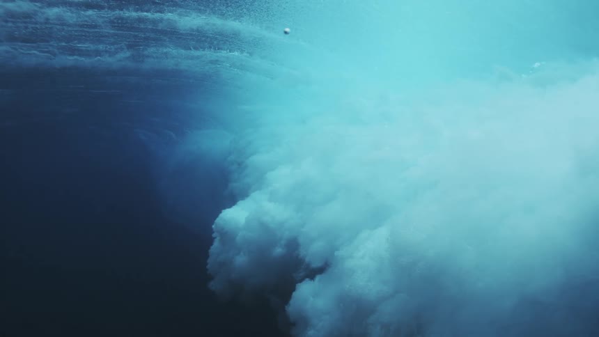 The deep ocean water violently forms waves at midday surging with power under the bright sun