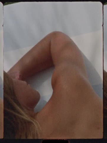 Woman lying in the sun on a white towel
