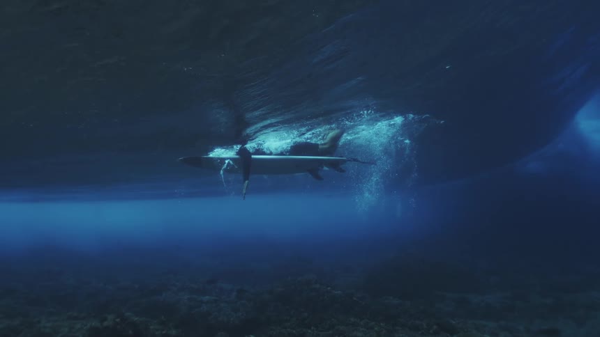 The surfer is paddling in the water above