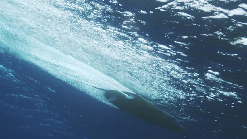 The surfboard is moving fast over the water