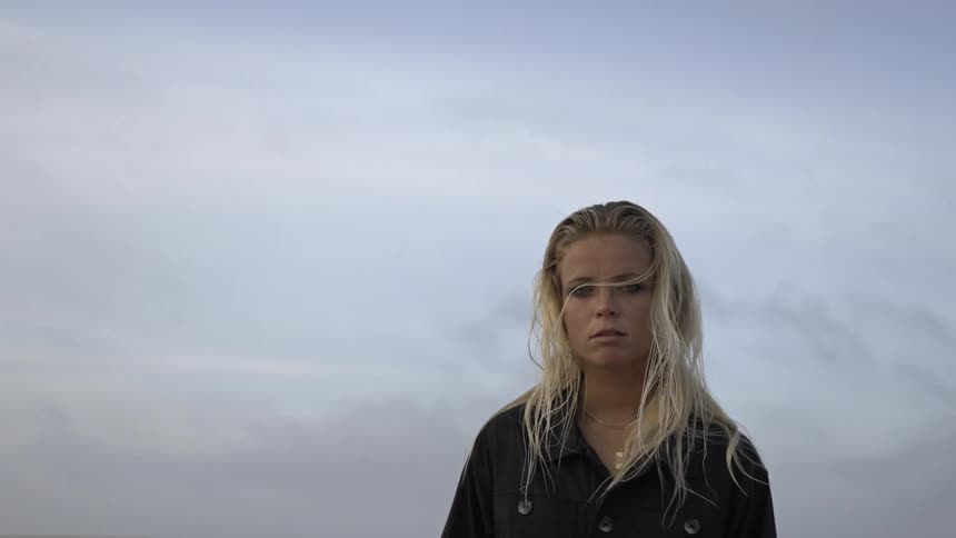 Woman with wet hair stares at the horizon in a desert landscape