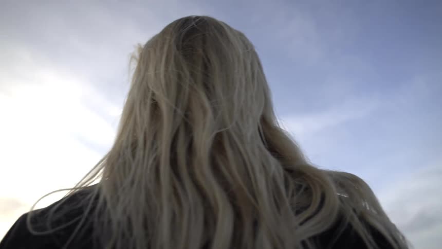 Woman with a serious expression looking toward the horizon amid the dunes