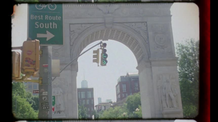 Monumental arch with a traffic light and sign indicating route south