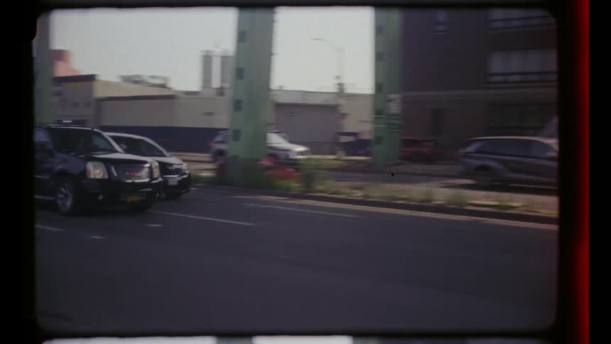 Wide shot of vehicles moving on a city road under a bridge
