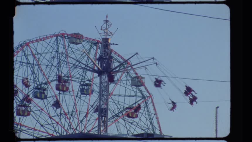 A vintage swing ride spinning amusement park under a bright blue sky