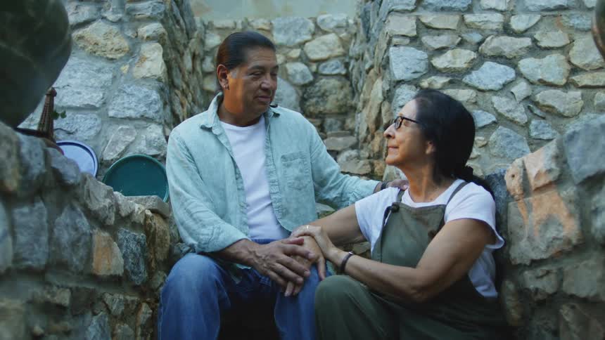 Senior couple embracing and looking at each other on outdoor steps