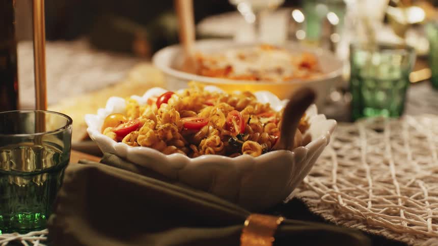 A dinner meal is served on a dining table with a glass of water placed neatly beside each plate of food