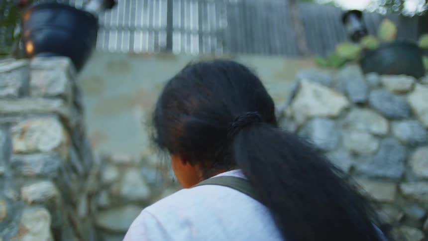 Woman with a calm expression looking upward in a stone outdoor area