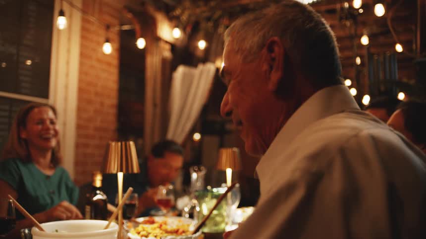 Family shares laughter during dinner in a cozy setting