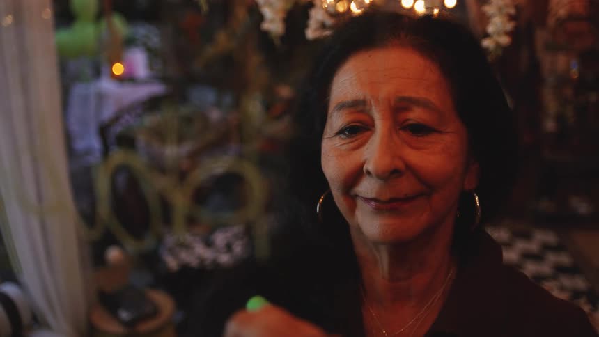Woman writes on a transparent glass under warm lights in a cozy setting