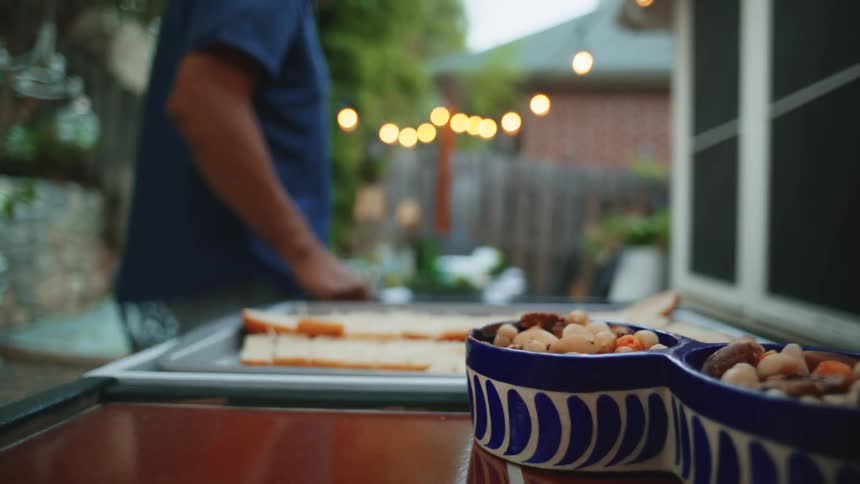 Bowls with nuts in focus while a man moves in the background
