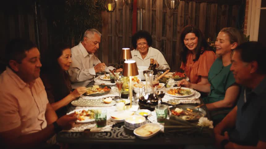 Family gathered for an outdoor dinner under cozy lighting