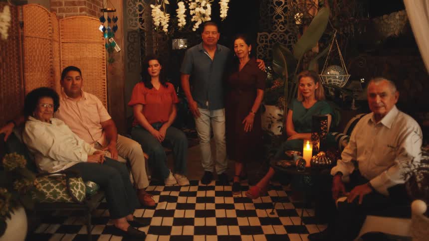 The family stand together smiling at home