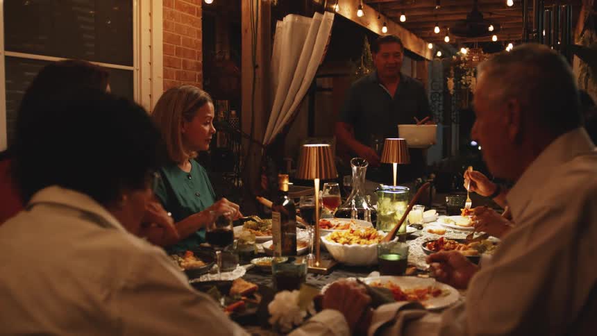 The family are having dinner outside together