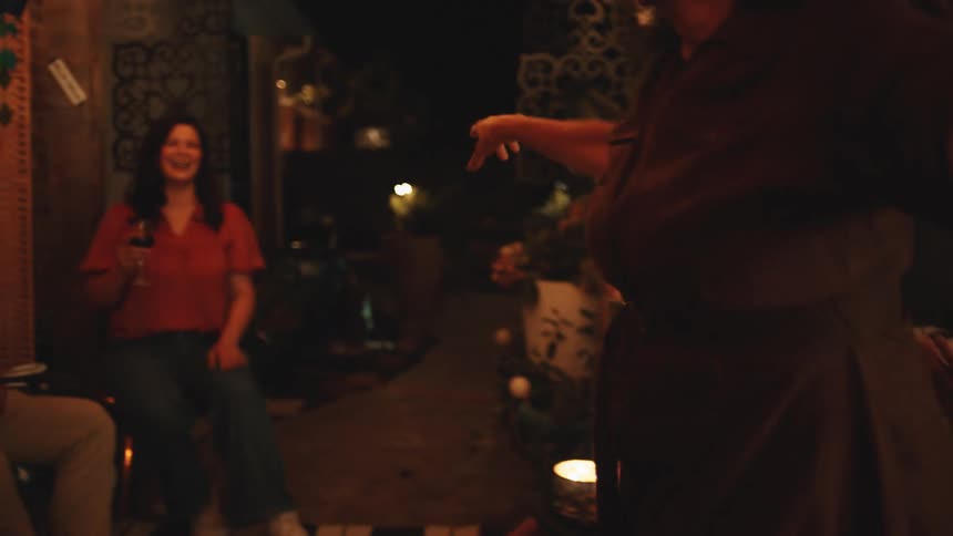 Lady dancing in a room at night with people watching her