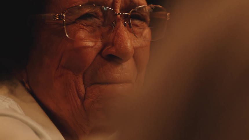 Closeup of an older woman in glasses with a deep emotion