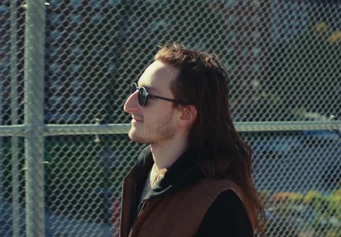The man smiles as he crosses the overpass