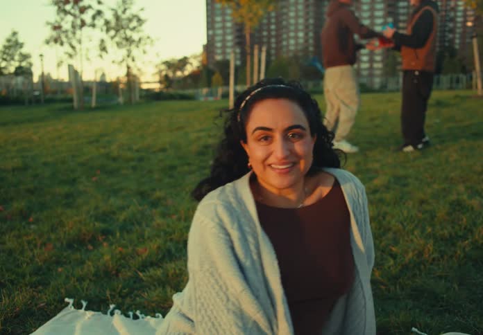 The woman smiles while sitting in the park