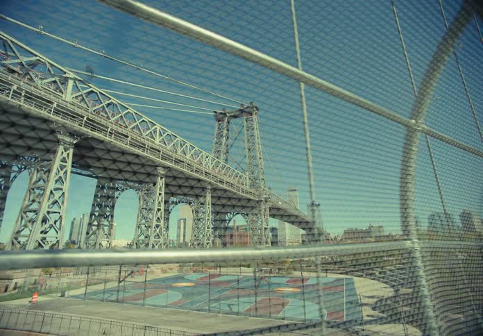 Walking along a bridge and looking at another bridge over a skate park