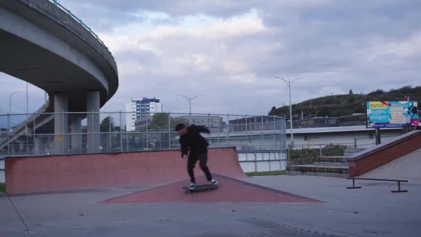 The man balances on his skateboard while skating in the park