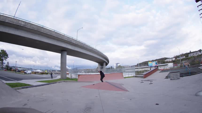 A man skateboarding in a skate park performing a trick