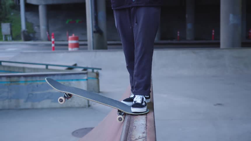 Person balancing a skateboard on a skatepark ramp