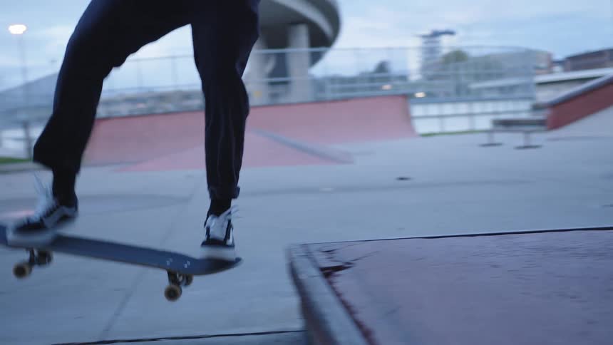 Closeup of skateboard wheels rolling on concrete ramp