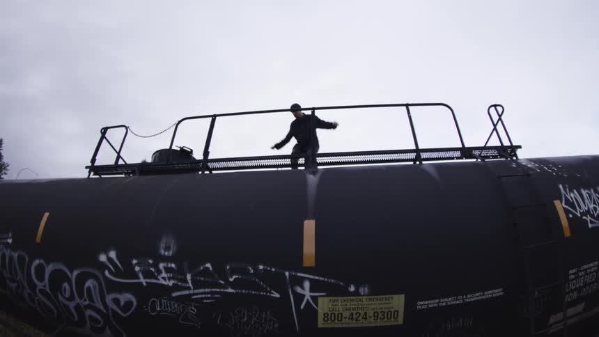 Person balances on a graffiticovered train car while riding a skateboard