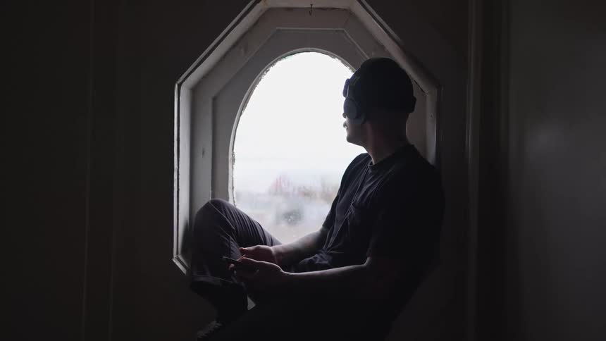 The man is sitting on the windowsill