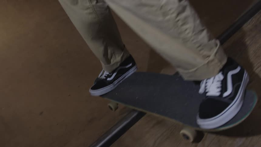 A young male adult skateboarding on an indoor ramp