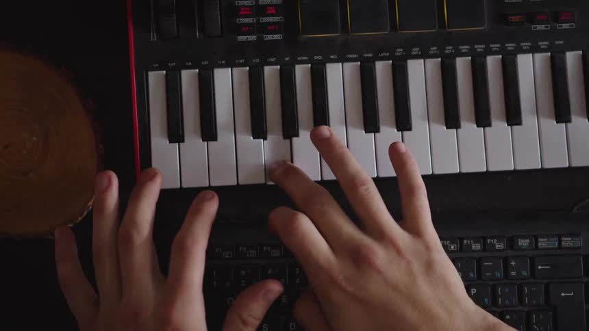 The man is playing the electronic keyboard