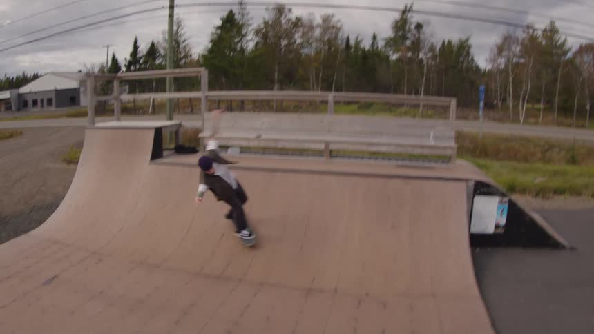 Person skateboarding on a wooden half pipe at a skate park