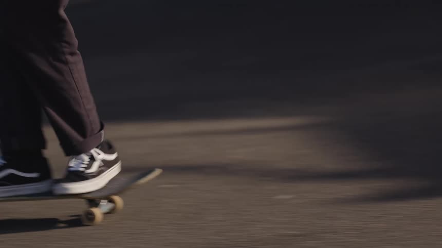 Person skateboarding on asphalt while in motion