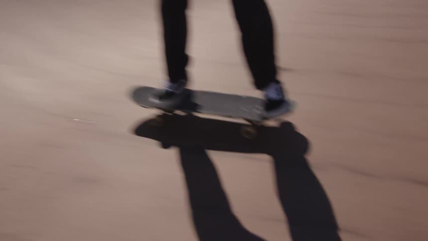 The video features a skateboarder riding down and then up a ramp or bank at a skate park the skater then jumps off the board catching it with their hands as they step onto the flat ground