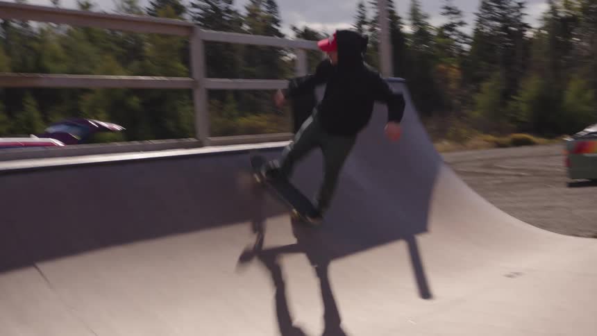 Person skateboarding on an outdoor ramp on a partly cloudy day