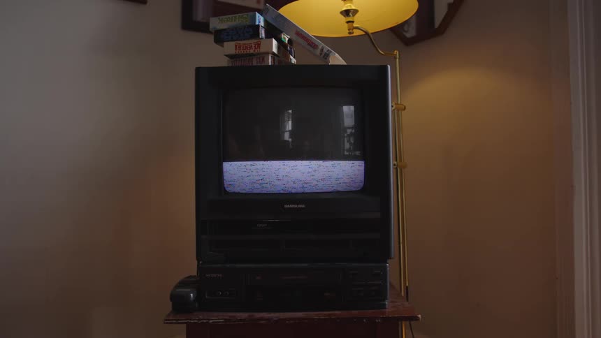 The man inserts and plays a vhs tape