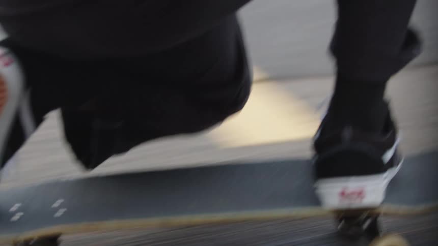 Person in motion on skateboard over paved surface