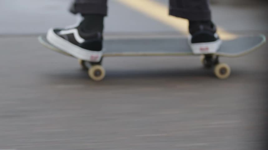 The skateboarder is moving fast on the street