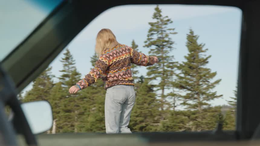 The woman walks by the car