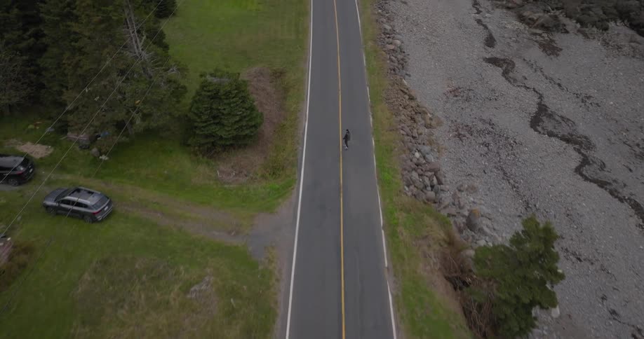 The man is skateboarding down the highway
