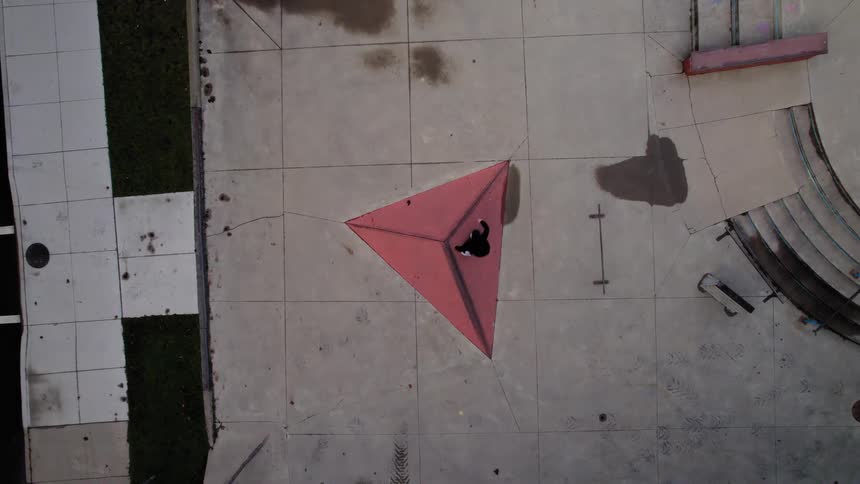 Topdown drone view of a concrete plaza with a red triangular structure