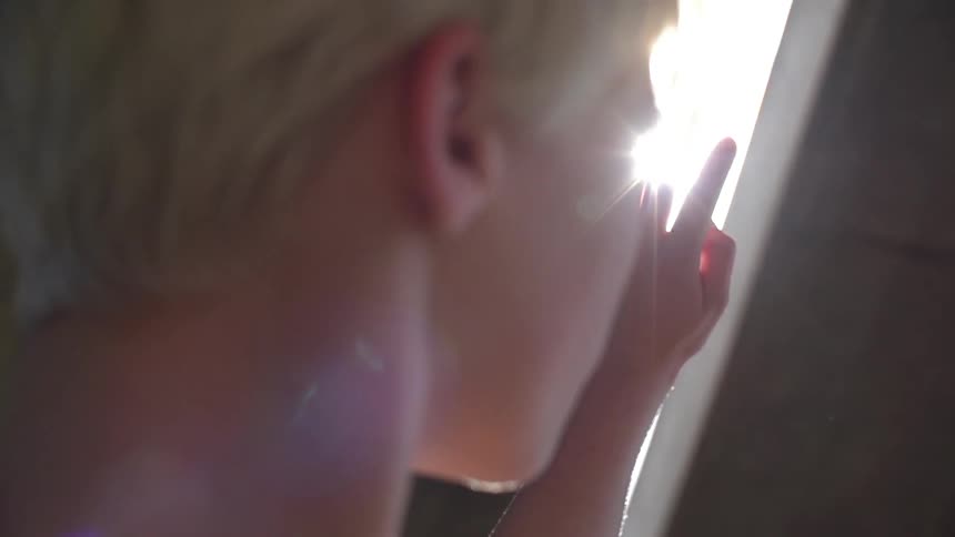 A woman shields her eyes from the bright sun